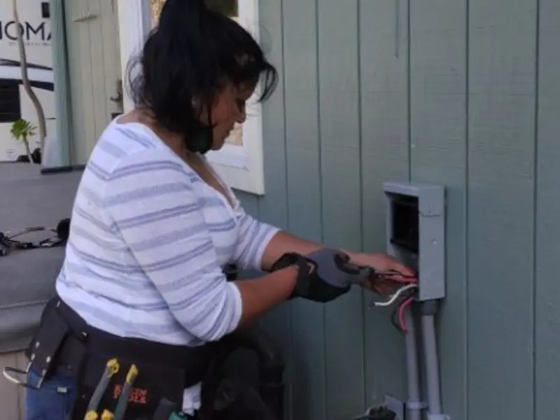 Licensed electrician wiring an exterior subpanel in Woonsocket